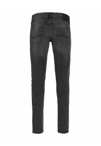 Black denim jeans with a slim fit, featuring two back pockets and a belt loop, showcasing a subtle fade and smooth texture.
