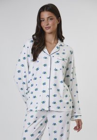 Wei�ßes Pyjama-Set mit blauem Blumenmuster, bestehend aus einem Hemd mit Kragen und langen Ärmeln. Abgerundet mit dunkelblauen Paspeln an den Kanten.