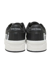 Czarne skórzane sneakersy z białą podeszwą. Branding "bruno banani" na pięcie. Gładka tekstura, okrągły design noska, wyściółka wokoło kostki.