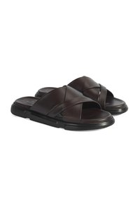 Donkerbruine leren slidersandalen met een kruisbandontwerp, voorzien van een dikke zwarte rubberen zool en een gladde textuur.