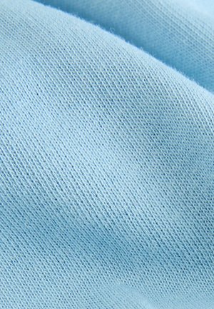 Lichtblau katoenen stof met een zachte, gladde textuur en een fijne, gelijkmatige breipatronen. Subtiele glans benadrukt de geweven details.