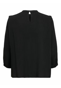 Blouse noire à manches trois-quarts, avec une découpe en forme de clé à l'arrière et un accent de bouton au poignet. Tissu lisse et léger.