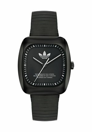 Montre carrée noire avec un bracelet en silicone texturé, index horaires blancs, aiguilles argentées et un logo Adidas sur un cadran noir.