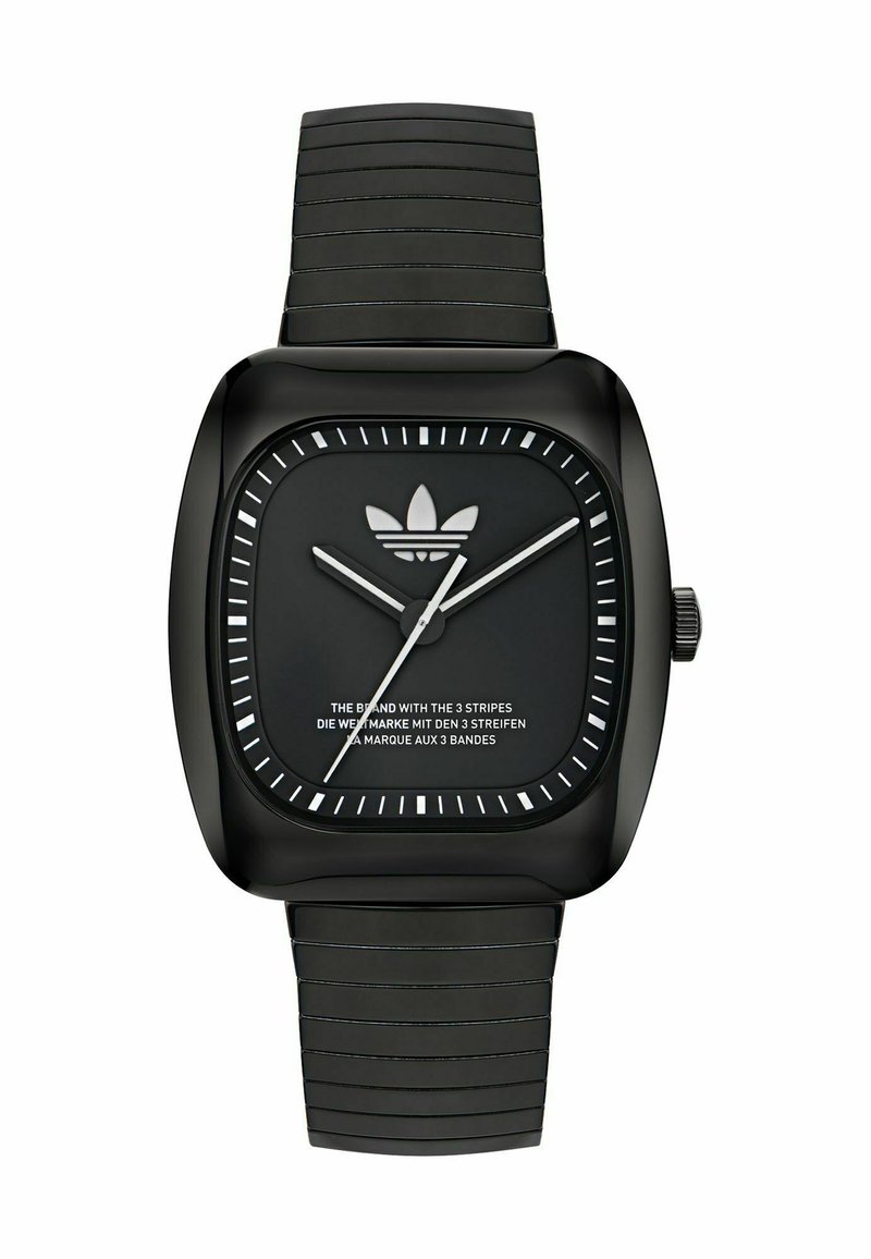 Must läikiv must kell, millel on tekstuuriga silikoonist rihm, valged tunni tähised, hõbedased käed ja musta digiplaadi peal Adidas'i logo.