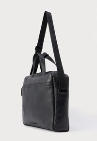 Sac messager en cuir noir avec sangle réglable, poche zippée et poignées supérieures. Texture lisse et design minimaliste.