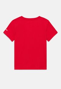 Κόκκινο βαμβακερό πουκάμισο με στρογγυλή λαιμόκοψη και κοντά μανίκια· διαθέτει μικρή λεπτομέρεια με λογότυπο στο αριστερό μανίκι· απαλή υφή.