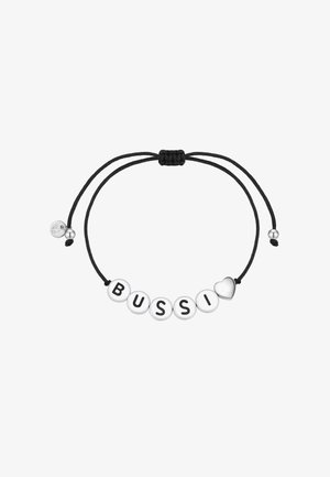 Pulsera con cordón negro y cuentas blancas que deletrean "BUSSI" con letras negras; presenta un pequeño charm en forma de corazón y cierre ajustable.