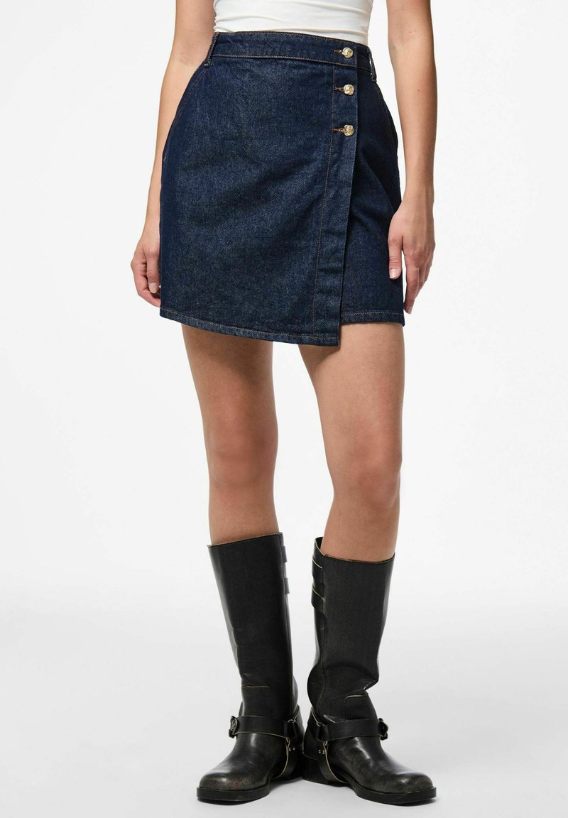 Dark denim mini skirt with a wrap design, featuring three gold buttons on the side. The fabric has a smooth texture.