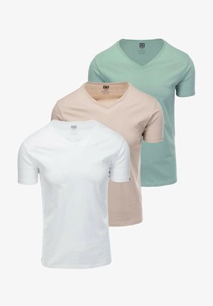 Trzy koszulki z dekoltem w serek w kolorze białym, beżowym i miętowym. Gładka bawełniana tkanina z krótkimi rękawami i widoczną metką wewnątrz dekoltu.