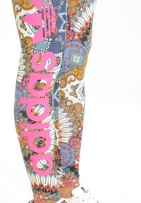 Legginsy o żywym, wielokolorowym wzorze, w którym dominują kolory takie jak niebieski, różowy i złoty, z wyraźnym różowym logo z boku.