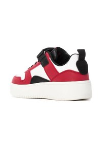 Zapatilla roja y blanca con acentos en negro, parte superior de sintético liso, cordones en la parte delantera y suela gruesa blanca. Presenta una pestaña trasera para facilitar el calzado.