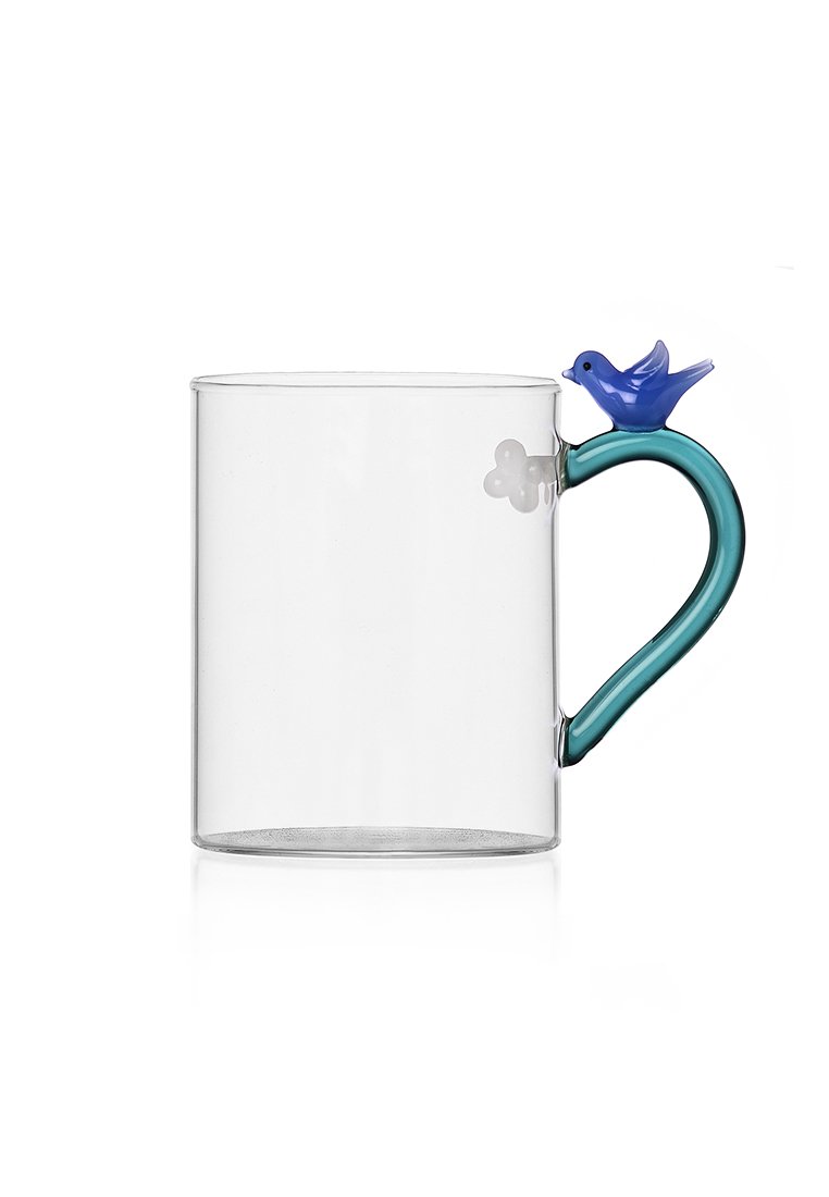 Przezroczysty szklany kubek z turkusowym uchwytem i niebieskim akcentem w kształcie ptaka. Cylindryczny kształt o gładkiej fakturze i minimalnych detalach dekoracyjnych.