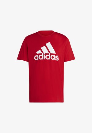Czerwona bawełniana koszulka z krótkim rękawem, z charakterystycznym białym logo Adidas. Okrągły dekolt i luźny krój w jednolitym kolorze.