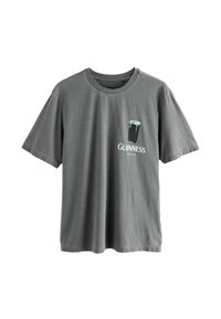 Graues Baumwoll-T-Shirt mit kurzen Ärmeln. Auf der Vorderseite befindet sich ein gedrucktes Guinness-Logo und ein Glas Stout. Mit Rundhalsausschnitt.