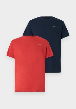 Dos camisetas de corte crew de manga corta: una roja y una azul marino. Cada una presenta un pequeño logo en el pecho en color blanco. Fabricadas en suave material de algodón.