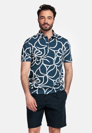 Polo à manches courtes bleu marine avec un motif floral blanc, fabriqué en tissu respirant, assorti à un short sombre.
