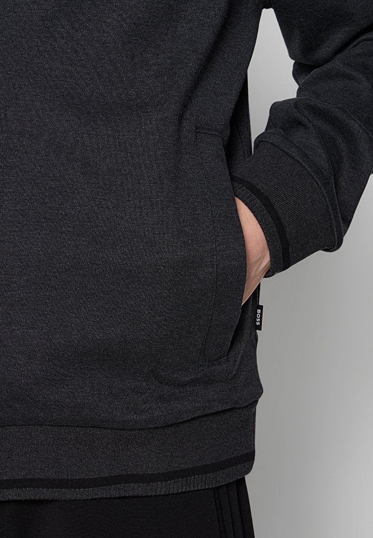 Zwarte sweatshirt tentoongesteld, met een soepele textuur, een kangaroo zak, ribbelmanchetten en een ribbel tailleband met subtiele gestreepte details.