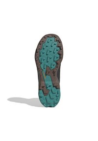 Trail running shoe outsole featuring a textured brown and turquoise rubber sole with a multi-directional tread pattern for traction.