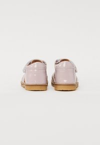 Sandali in vernice rosa con una finitura liscia, cinturino regolabile in Velcro e suola in gomma marrone. Design aperto sul retro per una maggiore traspirabilità.