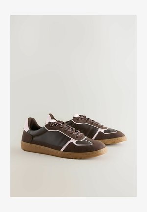 Braune stylische Sneakers mit pinken Akzenten und weißen Details auf einem hellen Hintergrund, ausgestattet mit Schnürsenkeln und einer strukturierten Gummisohle.