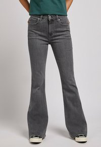 Harmaat levenevät farkut, joissa on sileä denim-pinta, viisi taskua ja hopeiset yksityiskohdat. Suunnittelussa on keski-haalari ja hieman venyvyyttä.