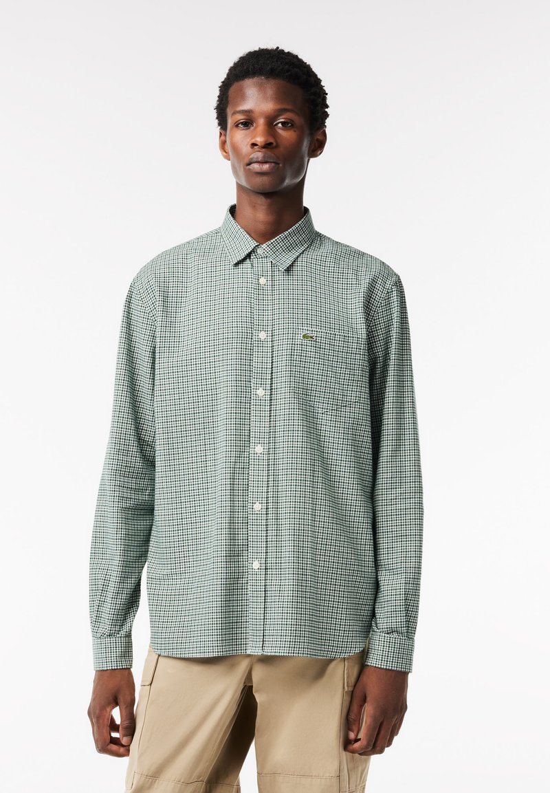 Grün kariertes Langarmhemd aus Baumwolle. Verfügt über einen Button-Down-Kragen, eine Brusttasche und ein kleines Logodetail auf der Brust.