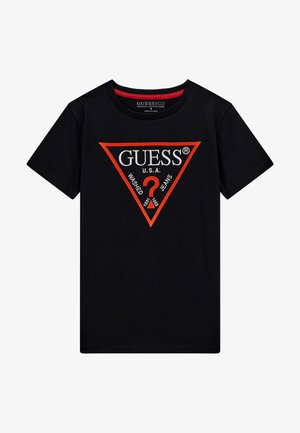 Must–must värvi puuvillane t-särk, millel on punane ja valge kolmnurgalogo, kus on kirjas "GUESS U.S.A." ja "WASHED JEANS". Klassikaline ümmargune kaelus.