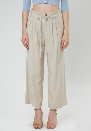 Beige wijde broek met plooien, een trekkoord in de taille en twee knopen. Soepele stof met een lichte glans en enkel-lange snit.