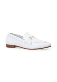 Witte leren loafers met een gouden accent aan de voorkant, platte bruine zool, amandelvormige neus en een gladde textuurafwerking.
