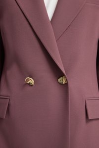 Dubbelzijdig blazer in mauve stof, met gouden hardware knopen, notched revers en voorzakken. Soepele textuur met subtiele glans.