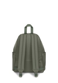 Mochila de tela verde con correas de hombro acolchadas, un asa superior y bolsillos laterales. El diseño es sencillo, sin patrones ni logotipos visibles.