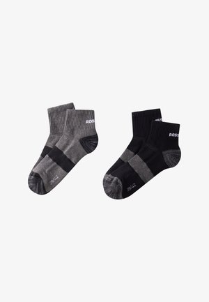 Fire par sokker til anklerne: to sorte, to grå. Hver par har ribbede manchetter og forstærkede hæle med kontrasterende horisontale striber.
