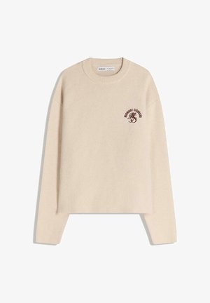 Beige neulepusero pyöreällä kaula-aukolla ja pitkillä hihoilla; etuosassa ruskealla painettu logo, pehmeä tekstuuri ja rento muotoilu.