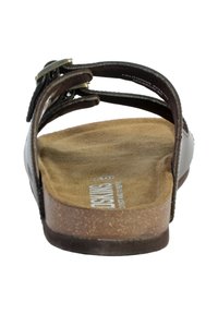 Brown sandal with a suede footbed and cork sole. Features multiple adjustable leather straps with a metal buckle. Smooth texture.