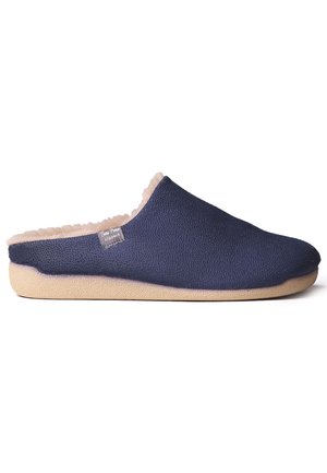 Chausson en tissu texturé bleu marine avec une douce doublure beige, semelle plate et une étiquette de marque discrète, conçu pour le confort et la simplicité d'utilisation.