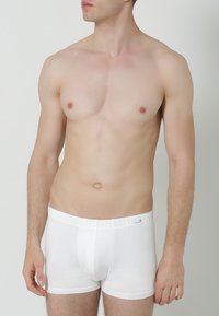 Witte katoenen boxershorts met een zachte textuur, voorzien van een elastische tailleband en een voorkantzak voor ondersteuning.