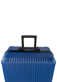 Maleta rígida azul con textura acanalada, asa retráctil negra y cierre de cremallera. Forma rectangular compacta, diseño ligero.