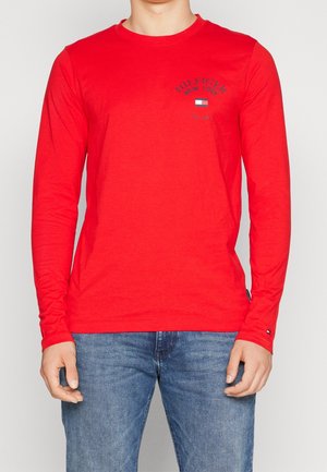 Rød langærmet t-shirt i bomuld med rund hals og en lille logo med tekst på brystet. Glat tekstur, afslappet pasform.