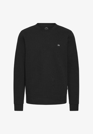 Musta dressipluus, mis on valmistatud tekstuursetest kangast, ümmarguse kaelusega, soonikuga varruka- ja alläärega. Vasakul rindkerel on väike valge logo.