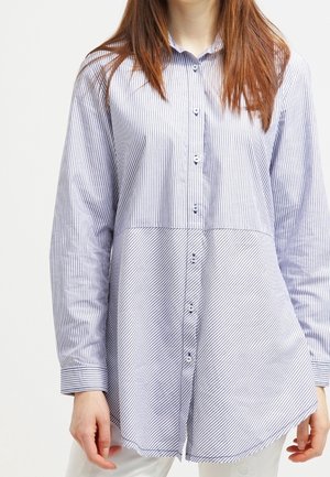 Camisa de botones con mangas largas, de rayas verticales azul y blancas, con dobladillo curvado y puños a rayas de contraste. Tela de algodón, corte relajado.