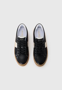 Svarta lädersneakers med vita detaljer, med rund tå, snörningsdesign och gummisula. Logotyp präglad på tungan.