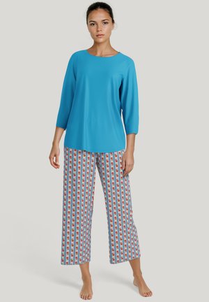 Lichtblauw, driekwart mouwtop, gecombineerd met wijde broek met een rood bloemenpatroon op witte en blauwe strepen. Soepele stof.