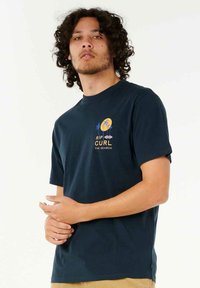 Navy blue t-shirt made of cotton with short sleeves. Features a graphic print with palm trees and text on the left chest area.