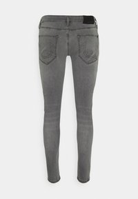 Šedé skinny džíny s hladkým povrchem, vybavené dvěma zadními kapsami s zakřiveným prošíváním a štítkem na pase. Přiléhavý střih.