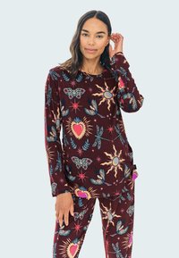 Set de pijama burdeos con mangas largas y pantalones a juego, que presenta un estampado abstracto colorido de mariposas, corazones y soles. Textura suave.