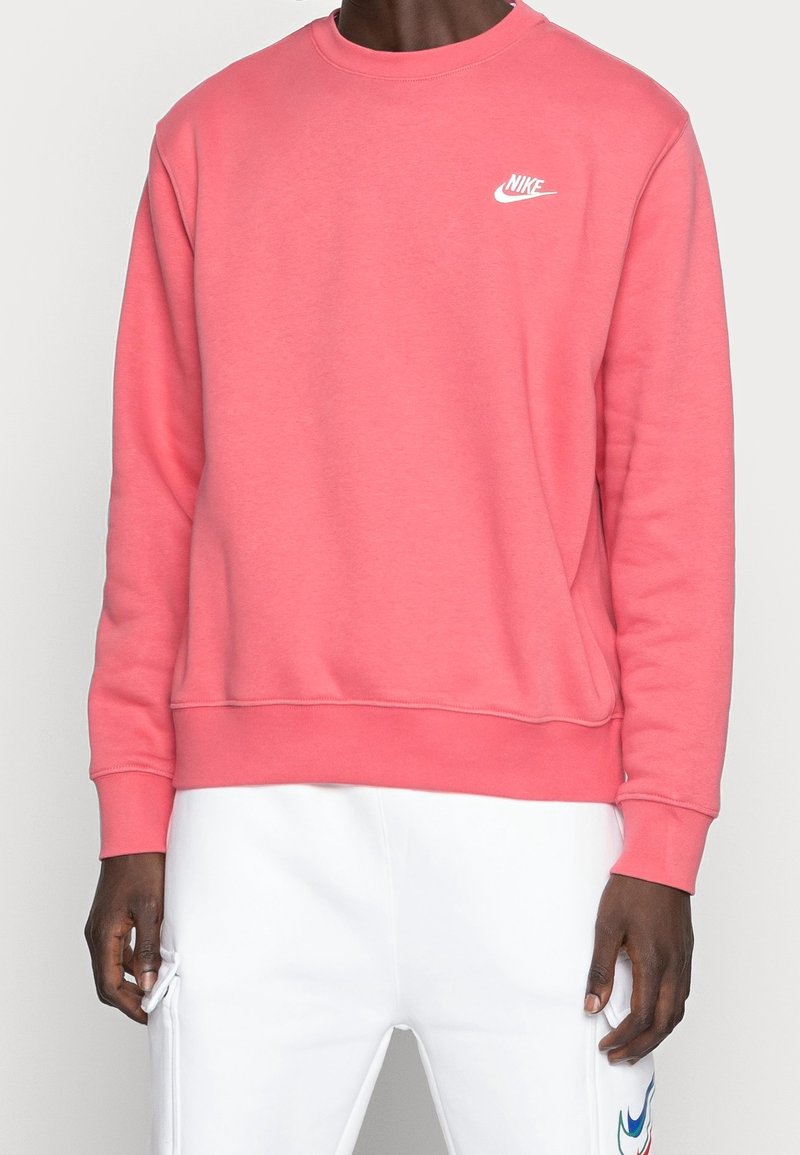 Rosa sweatshirt i mjukt tyg med rund halsringning, ribbade ärmslut och nederkant. Har en vit Nike-logotyp på bröstet.