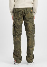 Cargobroek met camouflageprint in groene tinten, met meerdere zijzakken, een gestructureerde stof en een relaxte pasvorm. Geaccentueerd met een logopatch.