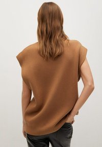 Brązowy sweter z dzianiny o luźnym kroju, z krótkimi rękawami i prążkowanym dołem. Tekstura wydaje się gładka i ciepła, odpowiednia do codziennego noszenia.