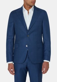 Męska marynarka w kolorze niebieskim, skrojona na miarę, z dwiema przednimi kieszeniami, zapięciem na jeden guzik, klapami w kształcie notcha oraz teksturowanym materiałem. Bielizna biała widoczna pod spodem.