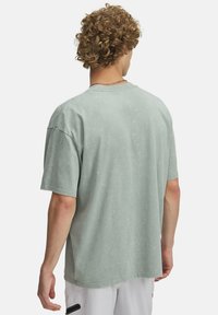 Overdimensioneret t-shirt med korte ærmer i falmet mintgrøn bomuld, med rund udskæring og en blød, tekstureret overflade med subtile farvevariationer.